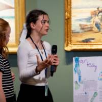 students during their WGVU interview, standing with their poster
